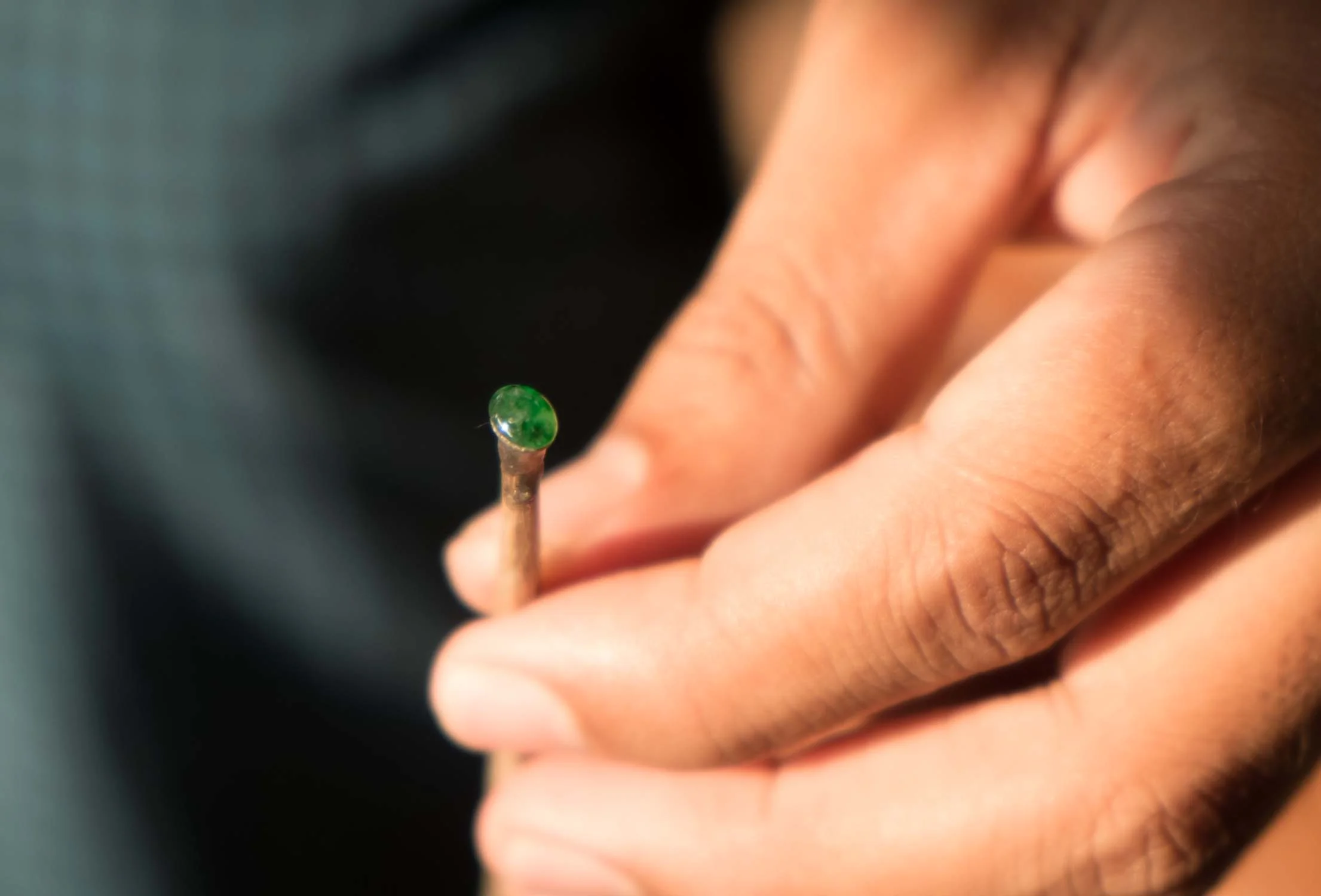 Near completed small piece of jade still on the dop stick.