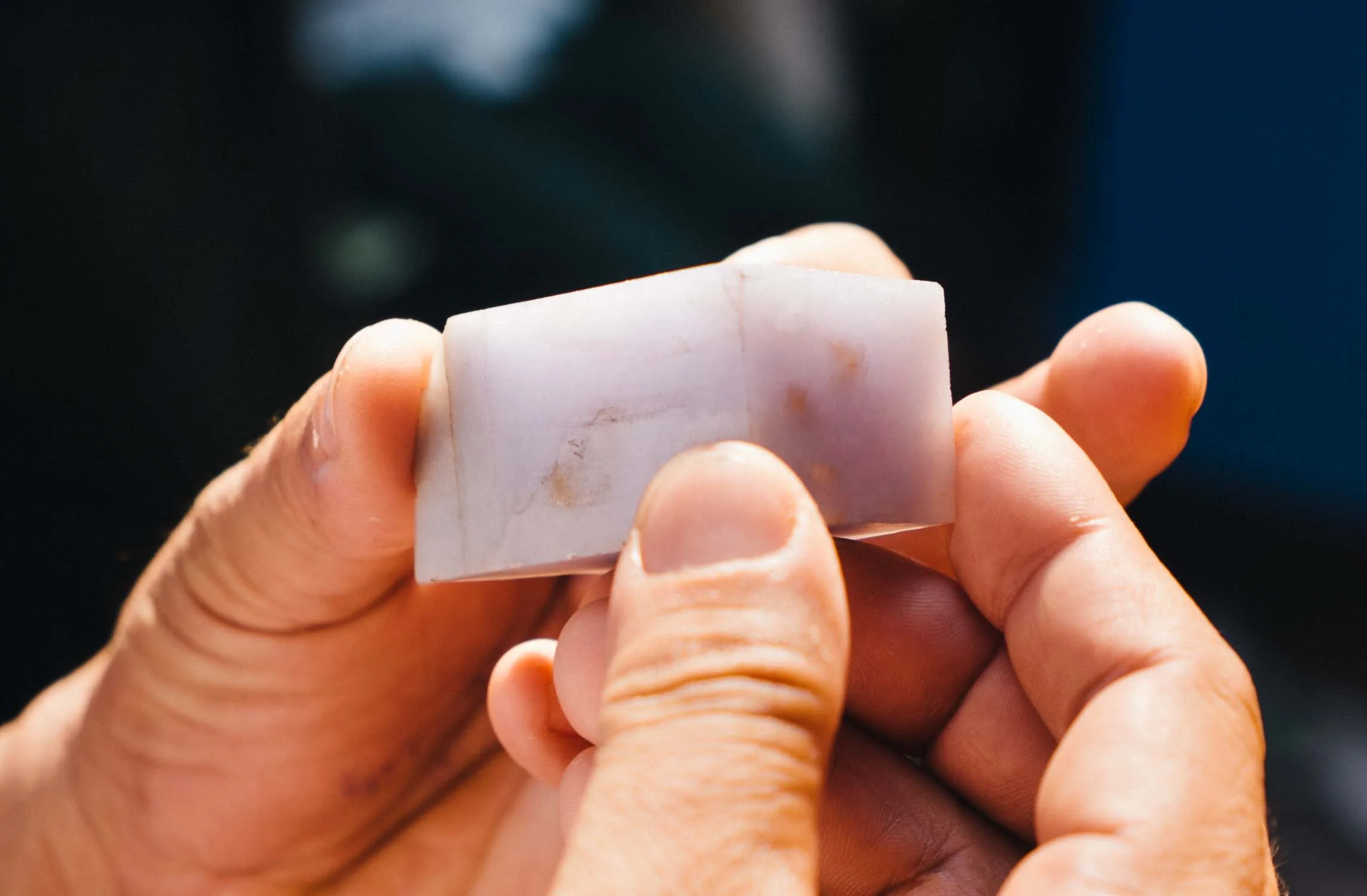 A block of lavender jade being evaluated.