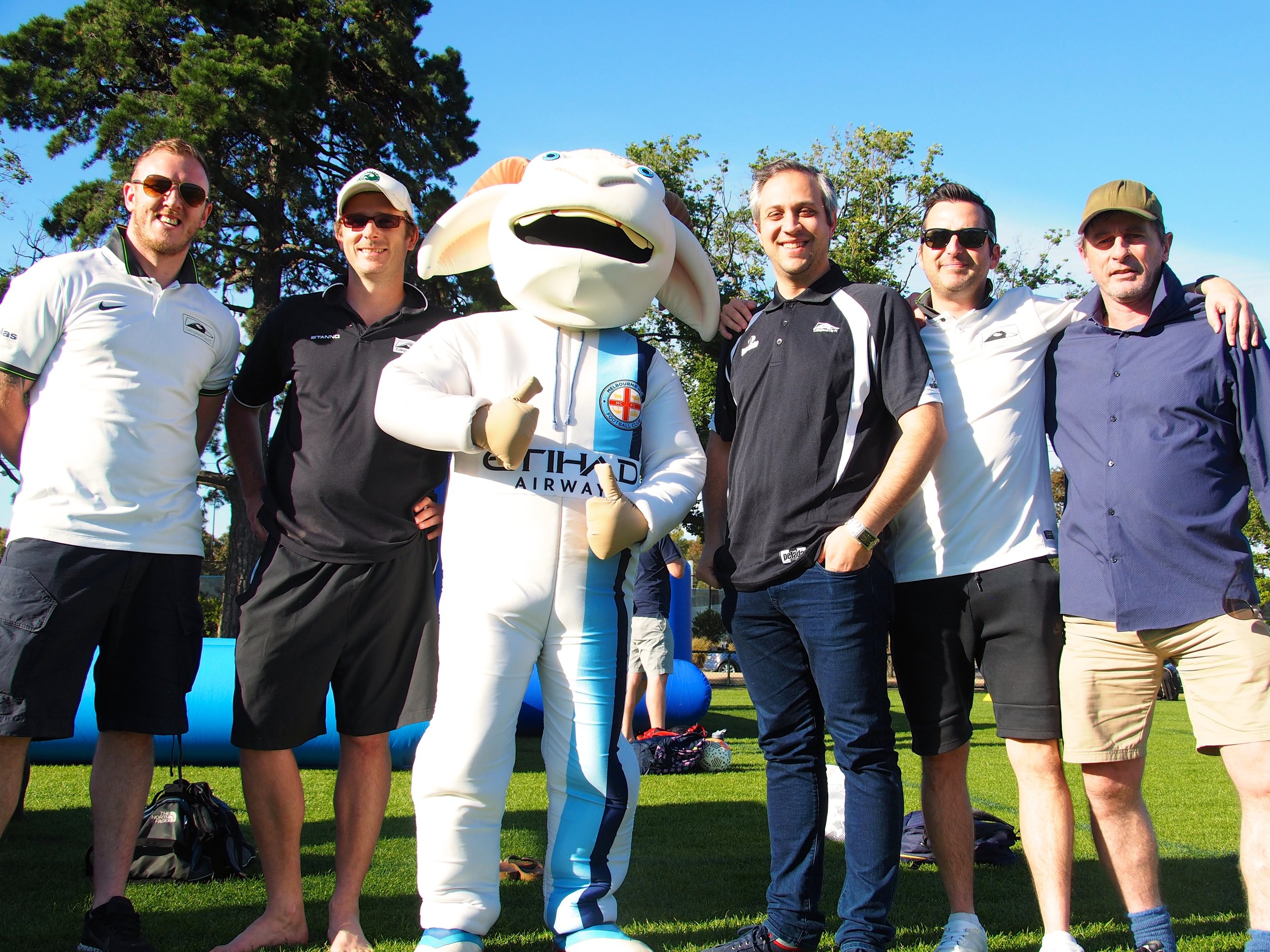 Coaches and staff from Collingwood City catch up with a Melbourne City mascot