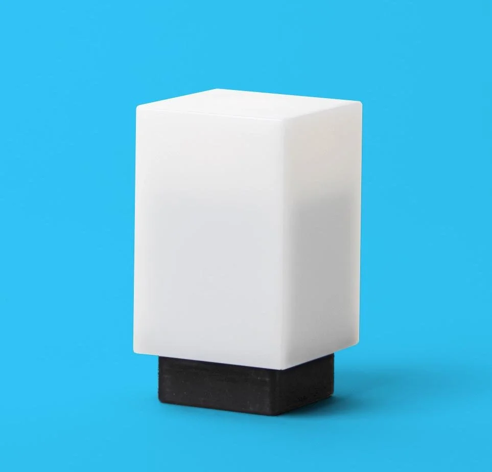 A white rectangular speaker with a black base on a blue background.