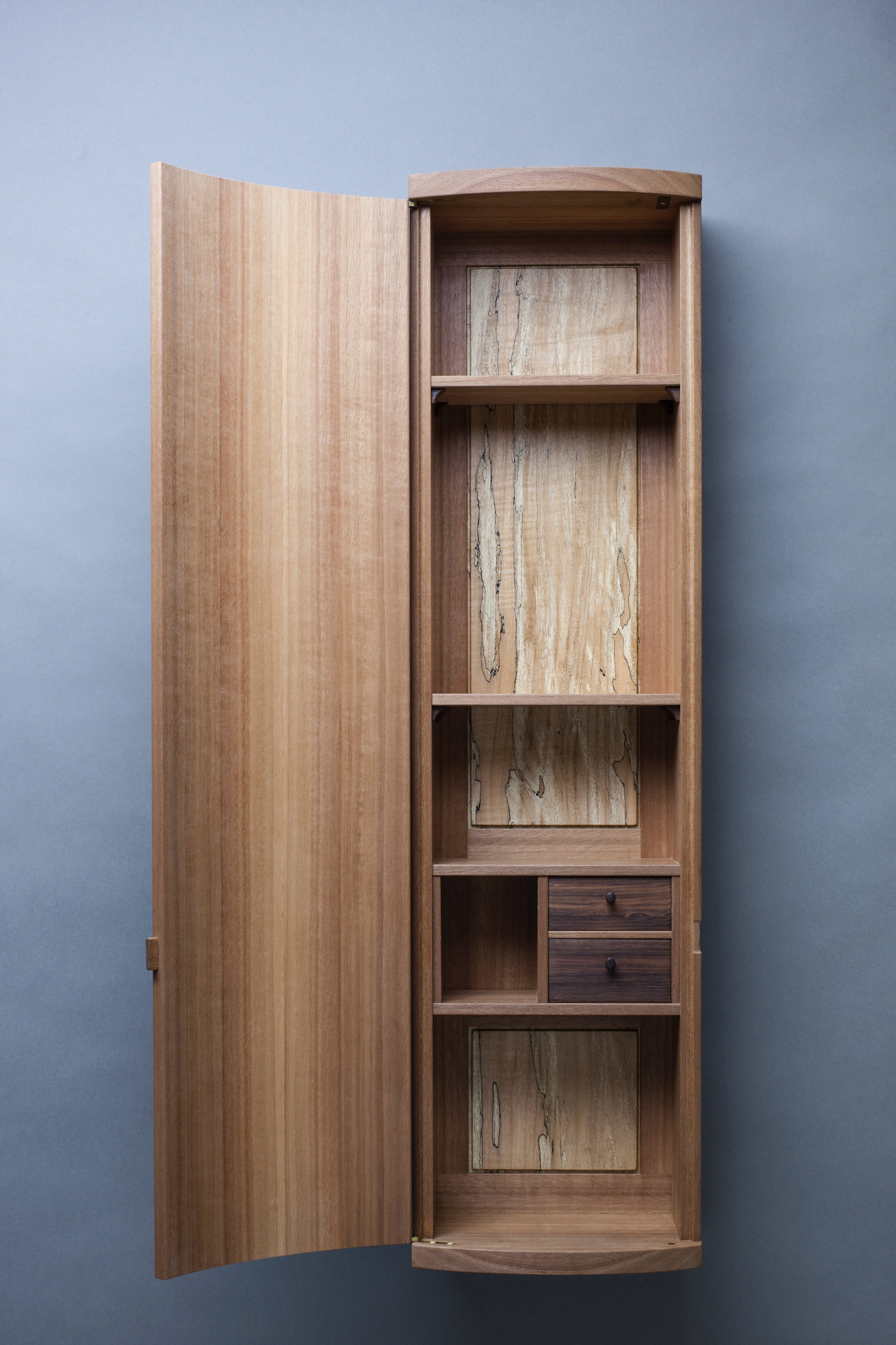  curved front cabinet in makore by Leanne featuring amazonian rosewood drawers and locally harvested spalted maple back panel photography by Tim Andres 