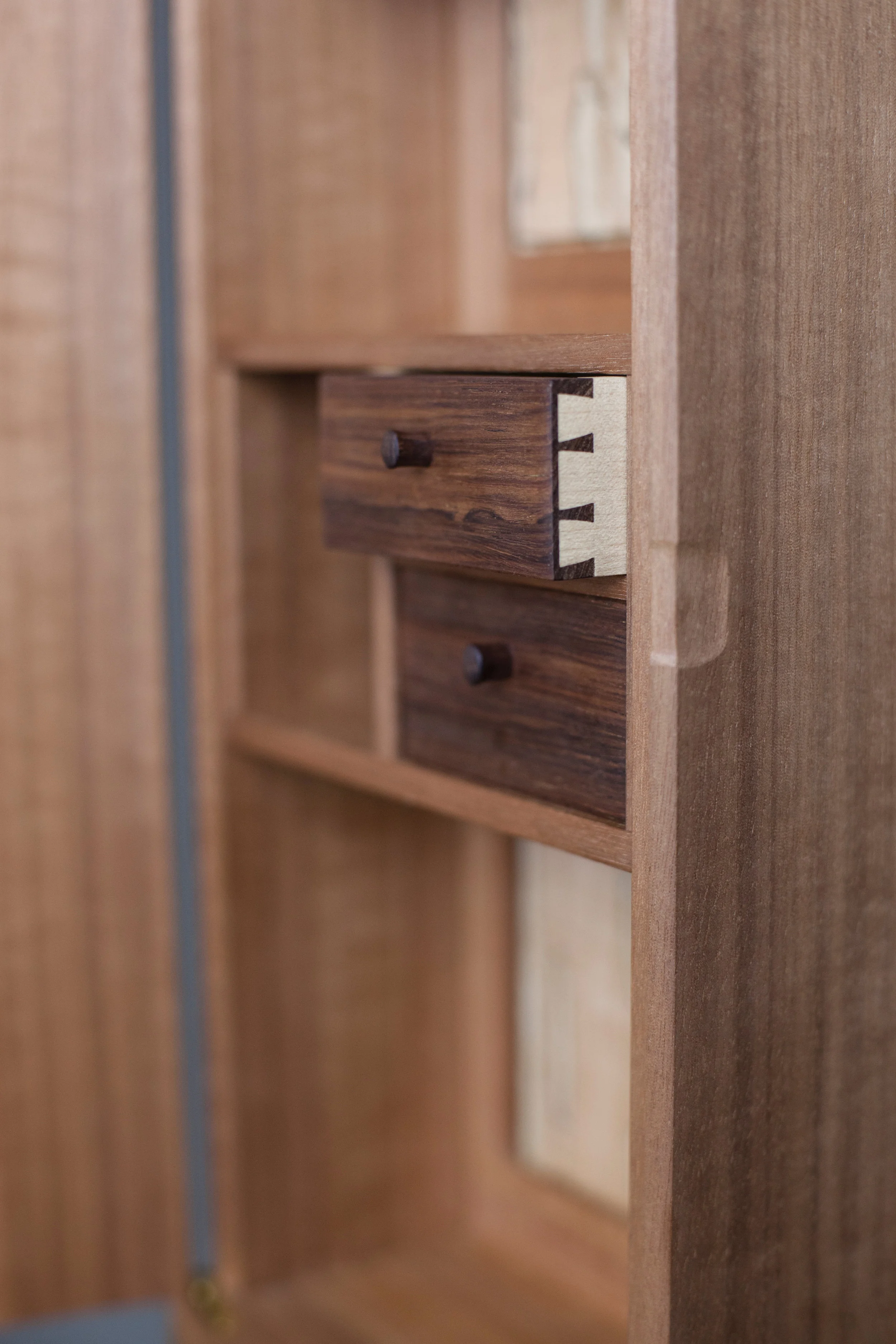  curved front cabinet in makore by Leanne featuring amazonian rosewood drawers and locally harvested spalted maple back panel photography by Tim Andres 