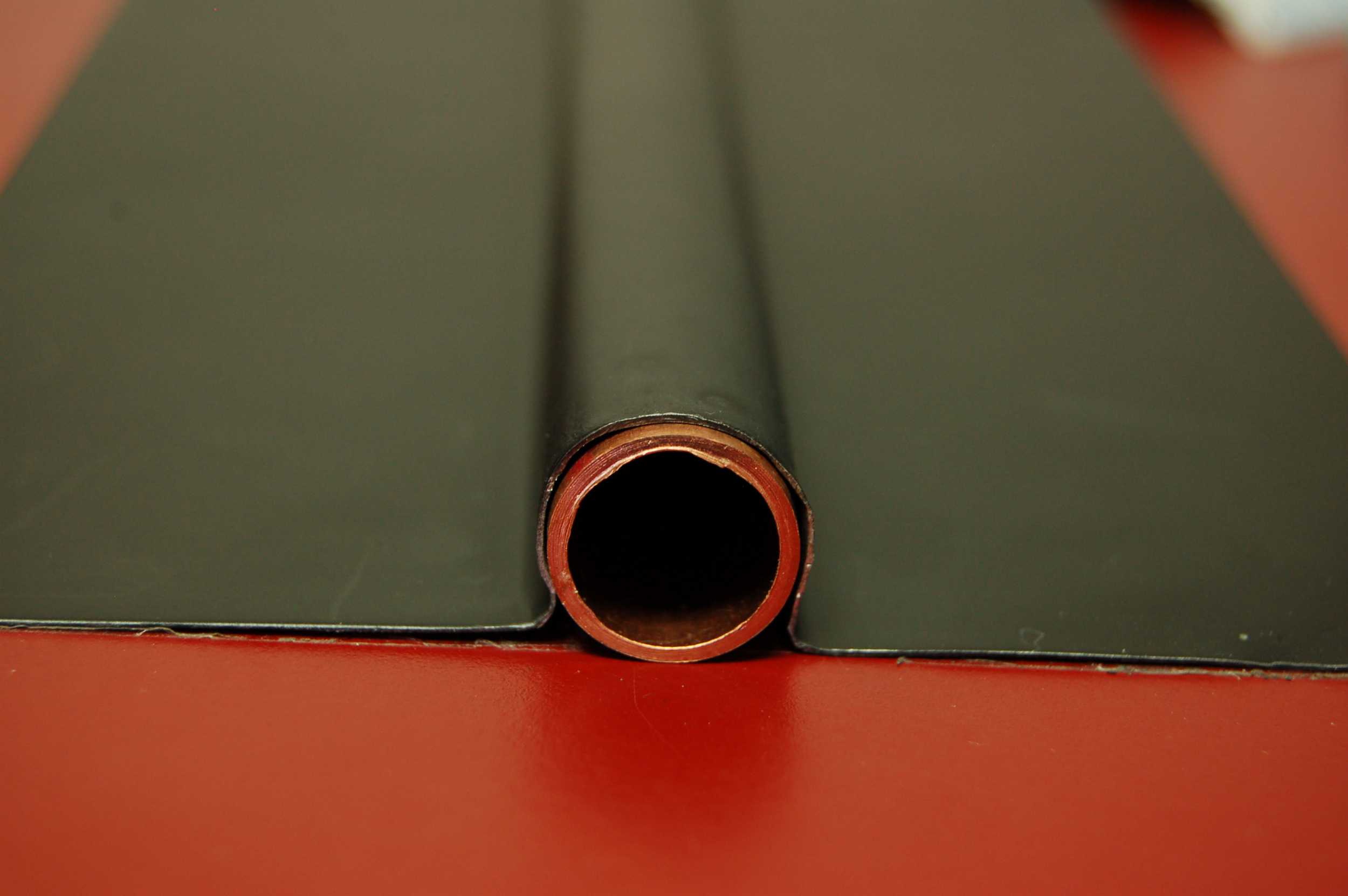 Sample #3 Typical sheet metal "Omega" plate used in the test. This plate measures 4.75" wide x .015" thick. The diameter of the channel measures nominally .640"* leaving a maximum .0075" air gap around the tube. This generic plate is actually formed well and best represents the class. At the same time some attention to installation is required for it to hold the shape shown, especially on heating, where thermal distortion can alter critical tube/plate and plate substrate relationships. *measurement taken with digital calipers Click to enlarge