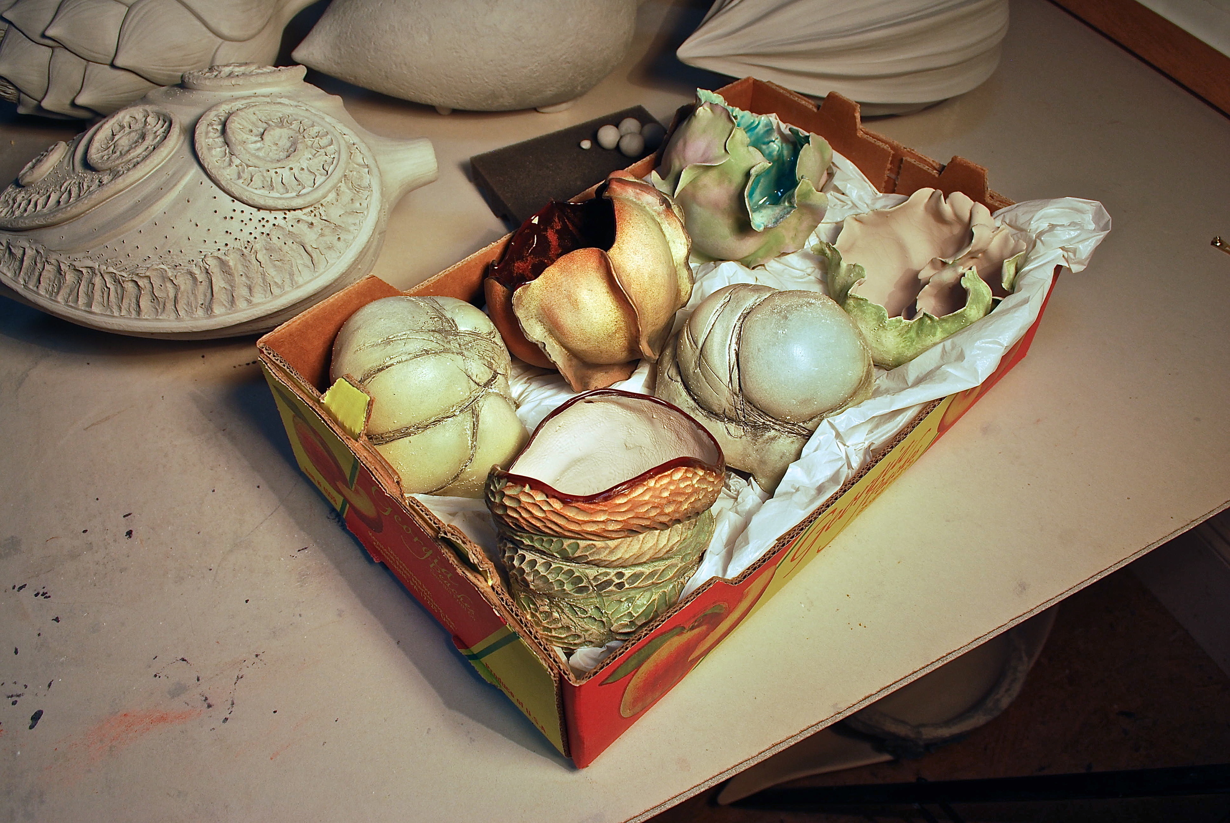 Meditation pieces nesting in a Costco peach box and ready for their 2nd firing