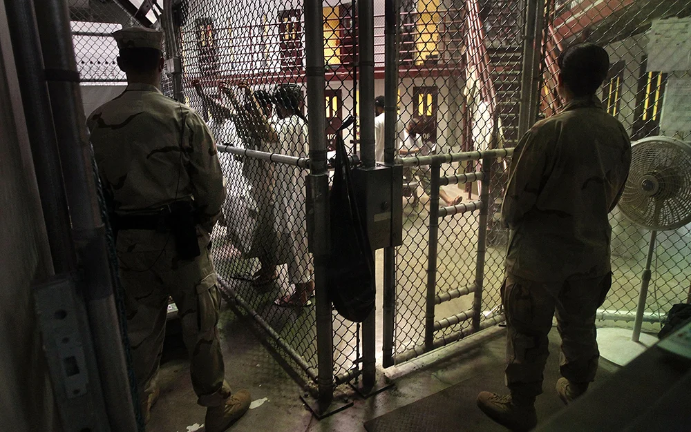 U.S. military guards watch detainees in a cell block at Camp 6 in the Guantanamo Bay detention center. (John Moore/Getty Images)
