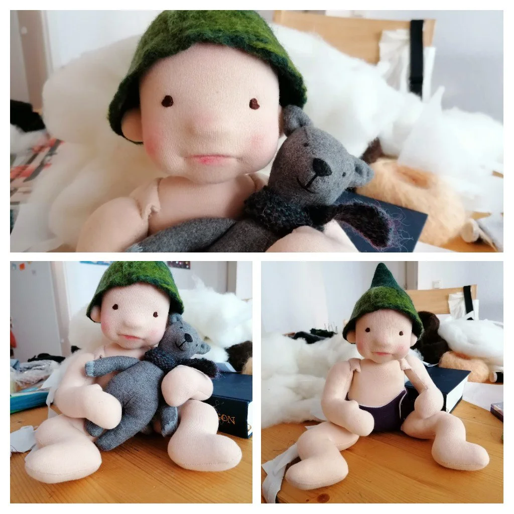 baby doll wearing felted green hat, made during online class with fig and me