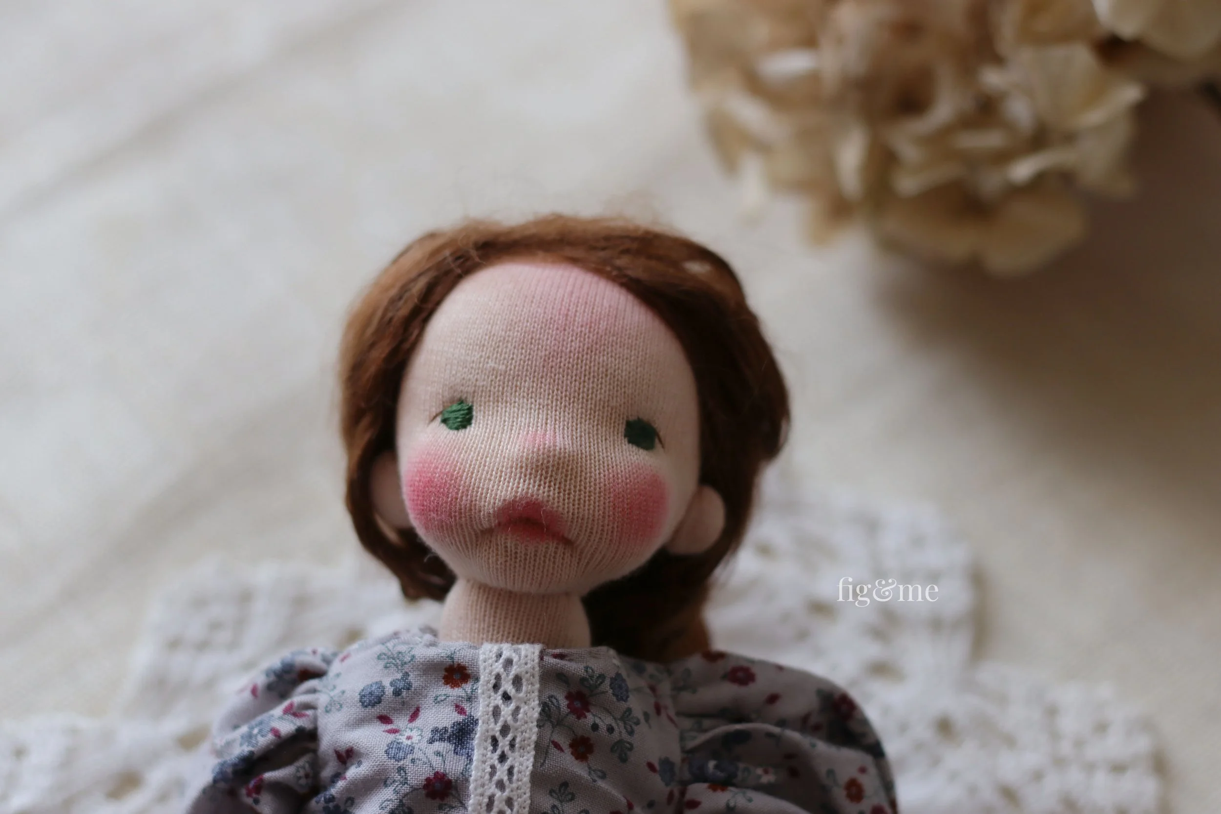 close up of wool sculpted doll, covered in doll skin, made in Waldorf style