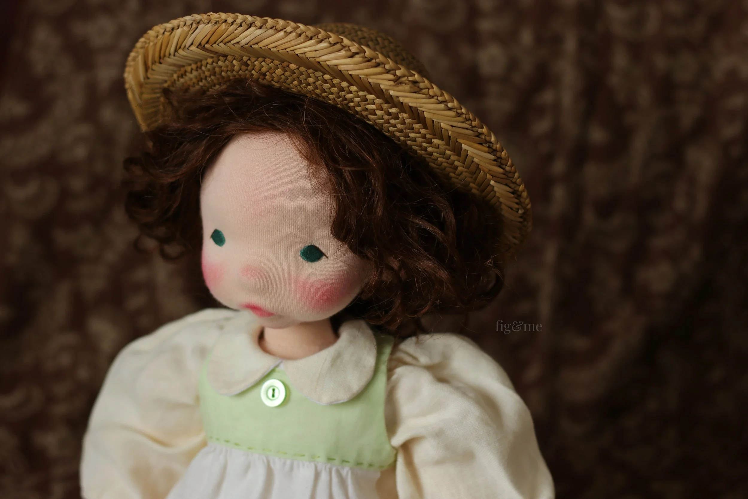 waldorf inspired art doll with brown hair, straw hat and old fashioned clothing