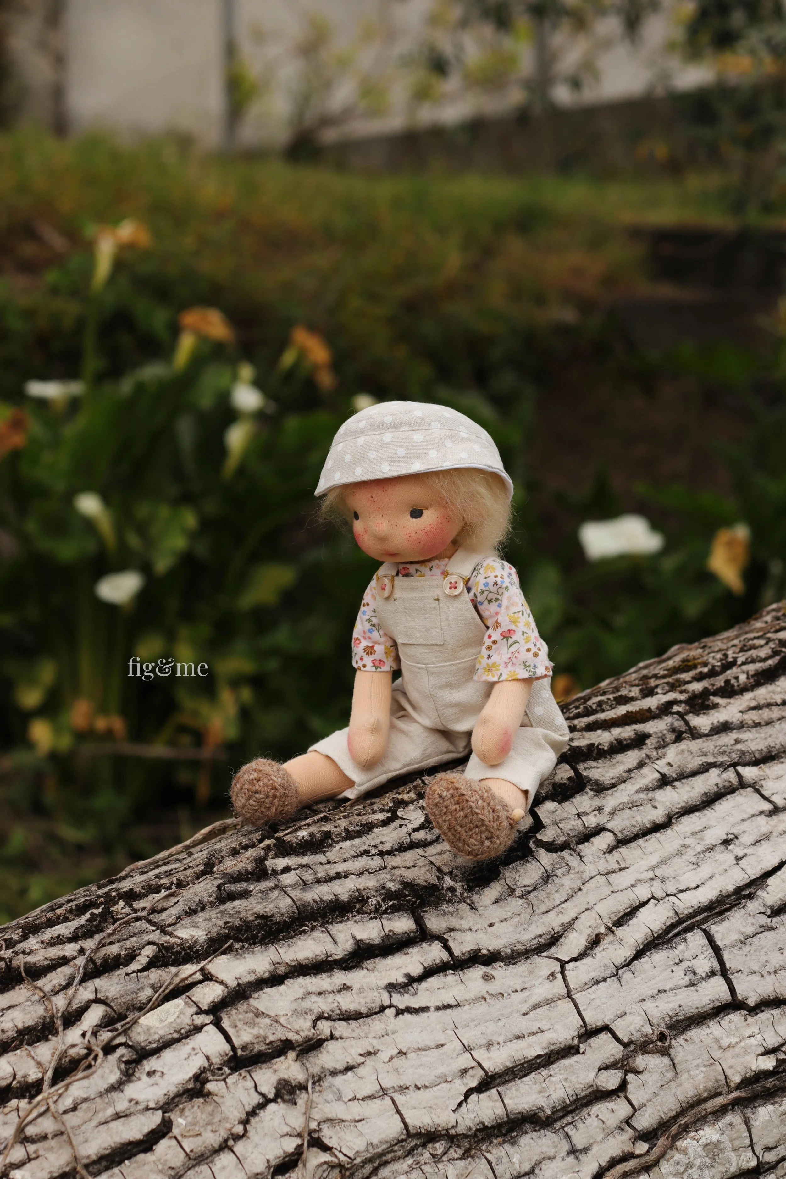 waldorf inspired doll sitting on a walnut tree