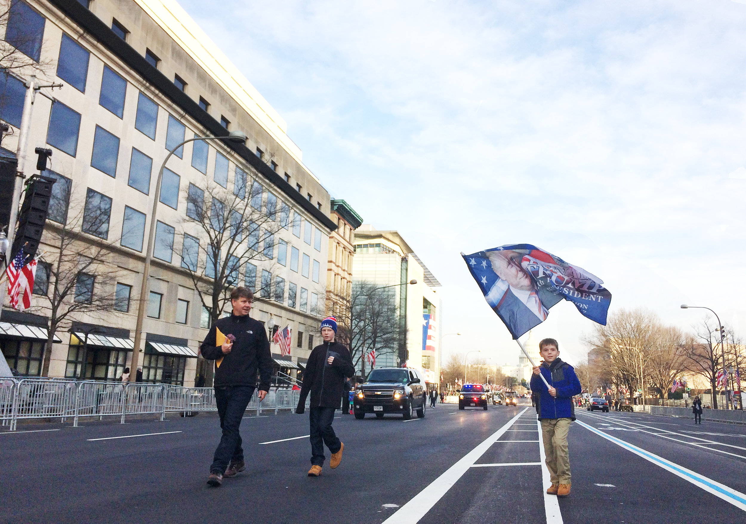A boy walked down Pennsylvania Avenue in Washington D.C., waving a flag picturing Donald Trump, on Jan. 19, 2017.