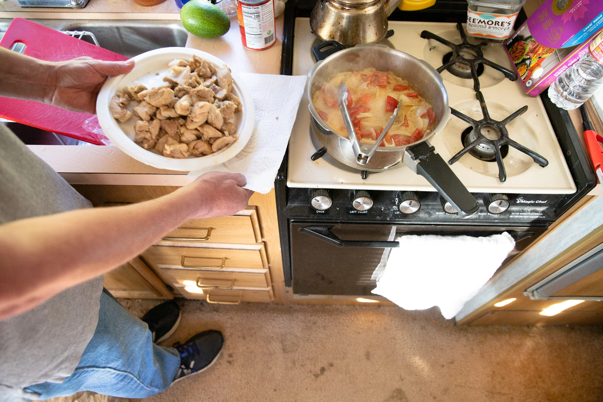 Scott Rodvold cooks Thai curry with chicken for dinner in his motorhome's kitchen on the evening of March 8.