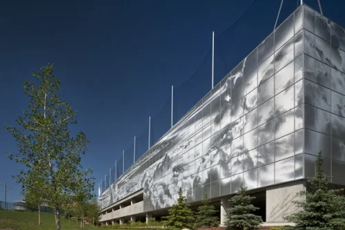 SAIT Parkade is a hidden gem as you can't really see it unless you are driving into the parkade are taking the LRT. The skin of the parkade is made of aluminum that has thousands of holes punch into it to allow for ventilation, as well as creating the pixilation that results in the mural of the Calgary's prairie sky. As a result of the changing sun light, the mural is constantly changing. Bing Tom Architects from Vancouver designed the Parkade, in collaboration with Vancouver artist Roderick Quin who designed the cloudscape mural.
