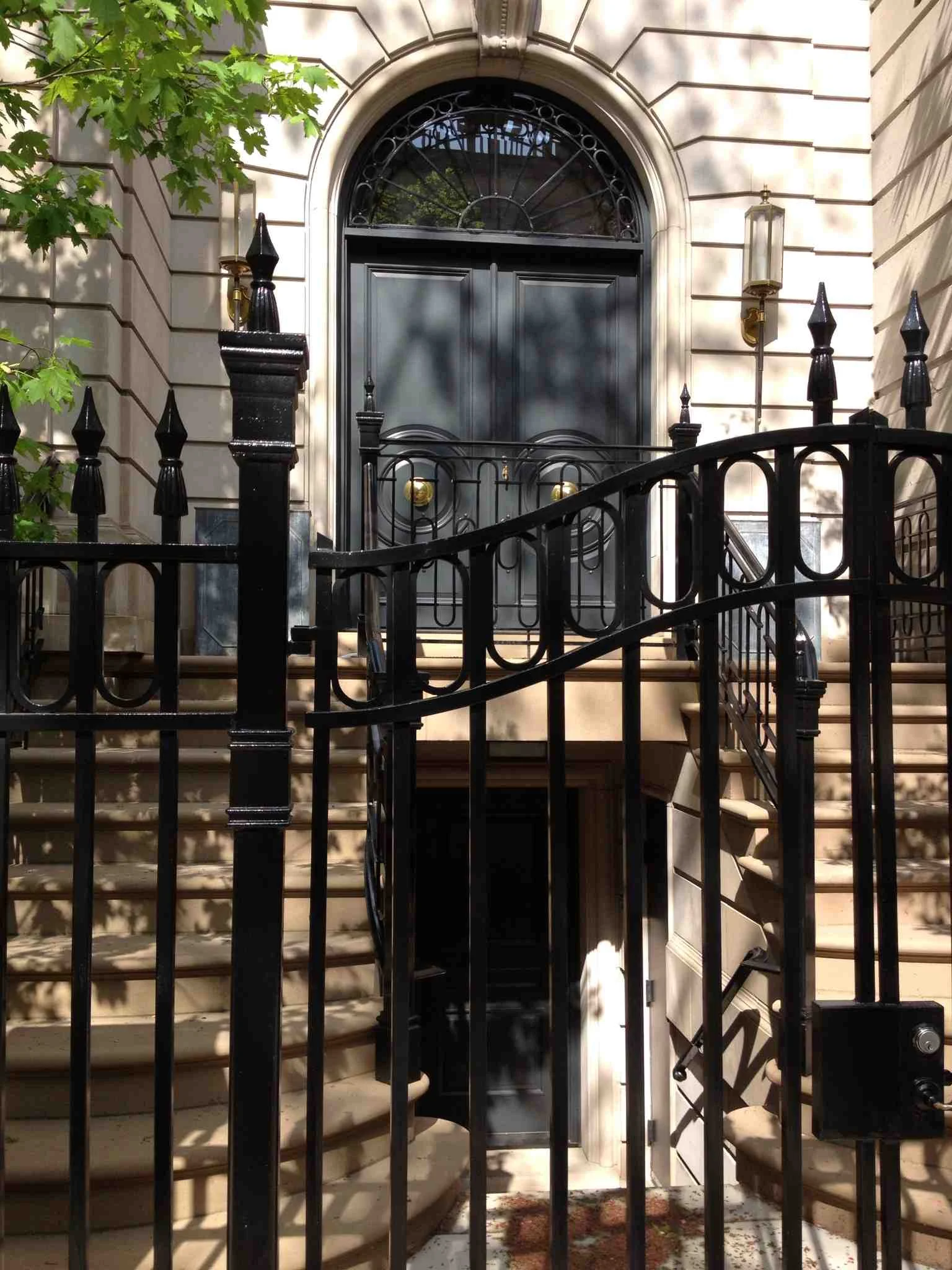 Another twin staircase to an upper door that is very rich in its ornamentation. While the entrance is gated you don't feel shut out like you do with the six foot wood fences so prevalent in new subdivisions. The lines are clean, concise and clear; making for a inviting sense of space. There is a wonderful interplay of the shadows and light from trees and decorative elements that soften the entire urban landscape. 