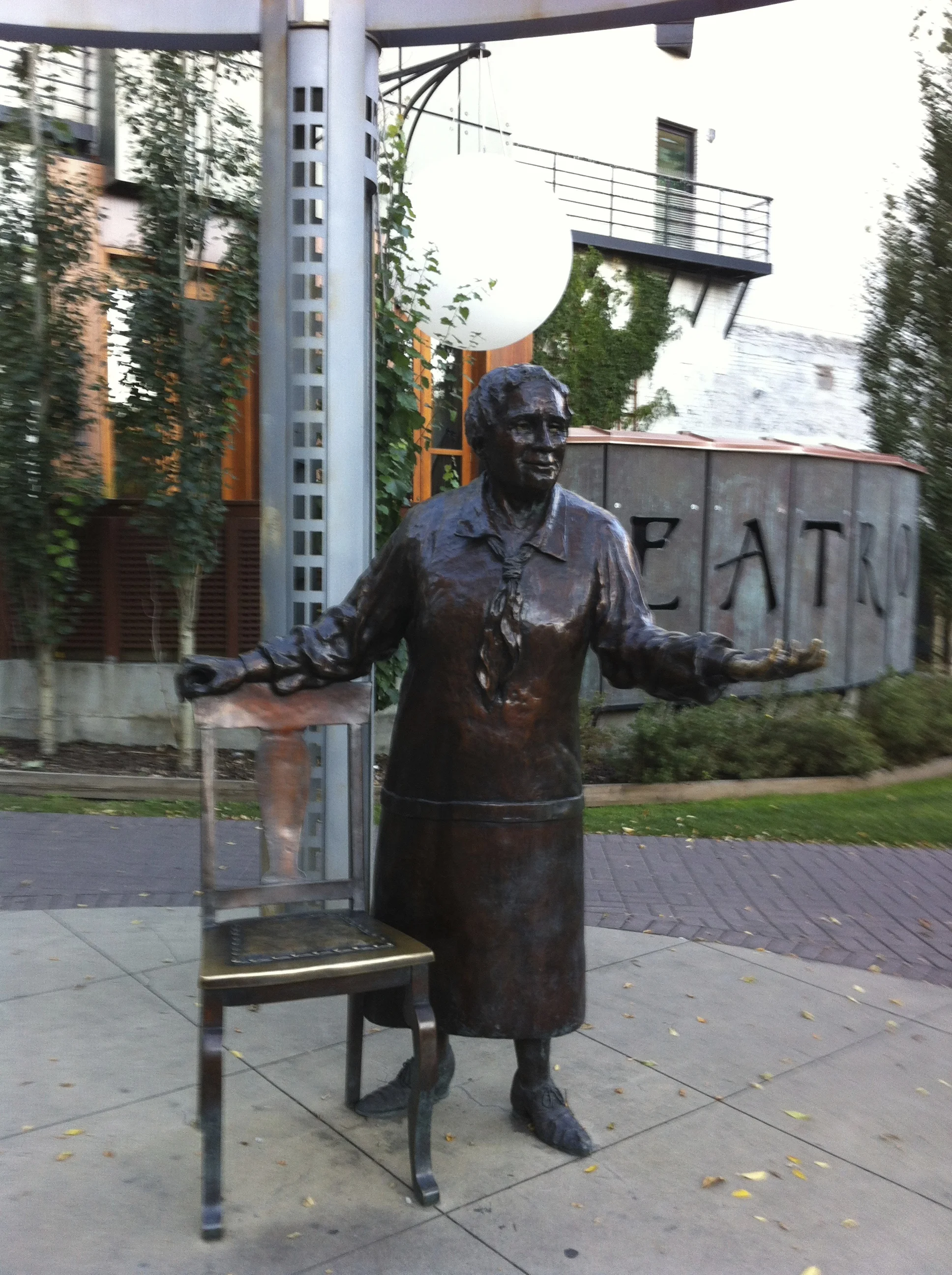Emily Murphy is standing by a chair gesturing to pedestrians to come and sit and think about how the world has changed?