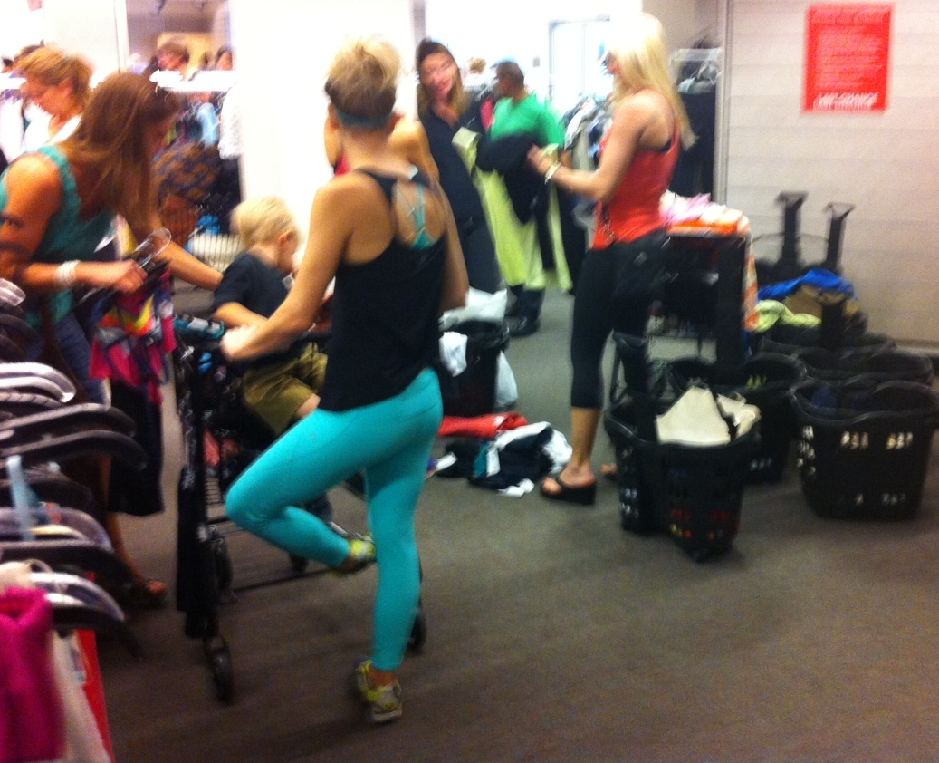 In another corner, the yoga women can't wait for the dressing room so they are trying on clothes over their own clothes. 