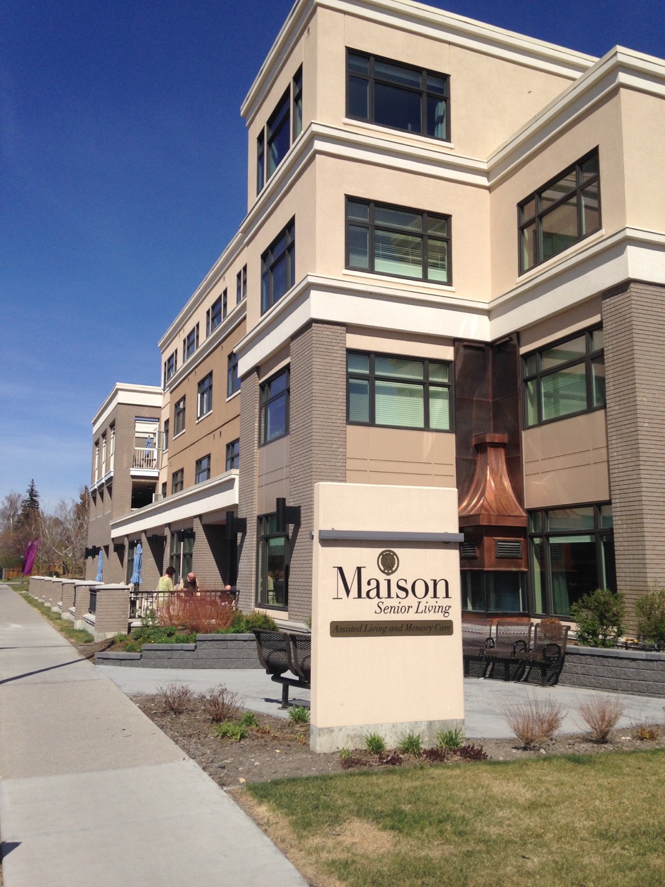 Maison's facade has a variety of materials in warm colours, as well as seating and patios to create a pedestrian friendly sense of place.