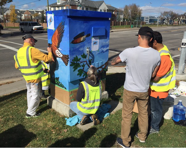 Driediger on the left working with the Crossroads community to add some ornamentation to their utility boxes. 