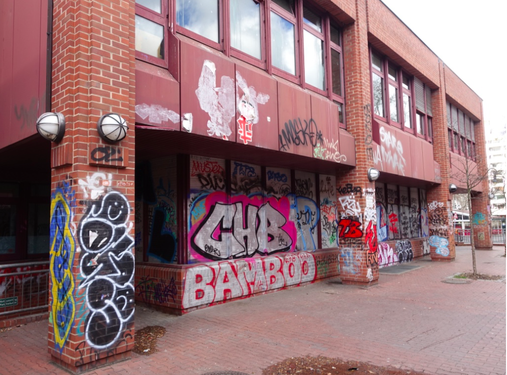 A Kreuzberg elementary school streetscape a block from the subway station and luxury apartments. There is an interior courtyard big playground where kids play like any other elementary school.