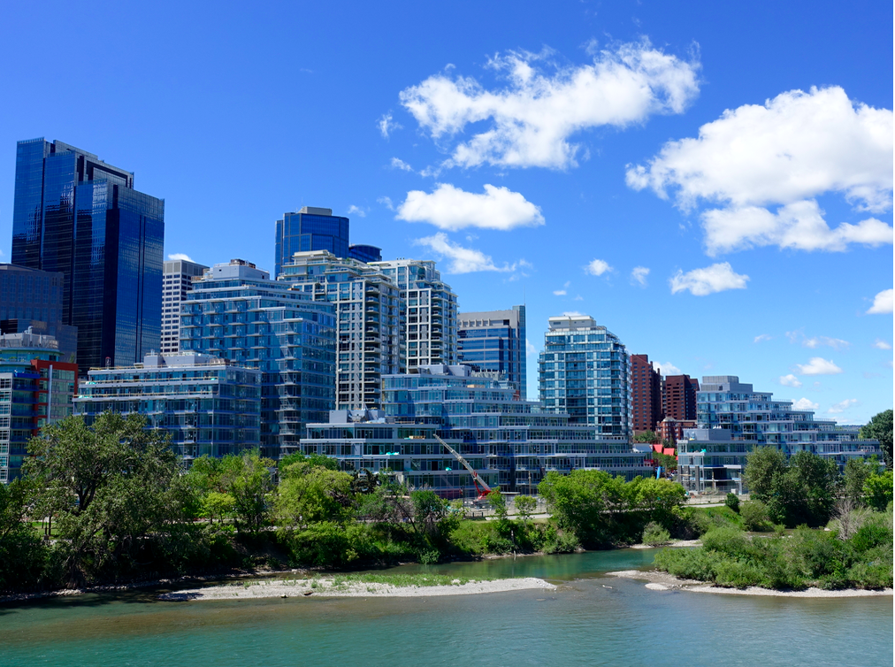 Bow River looking west with condos lining the shore and office towers in the background. 