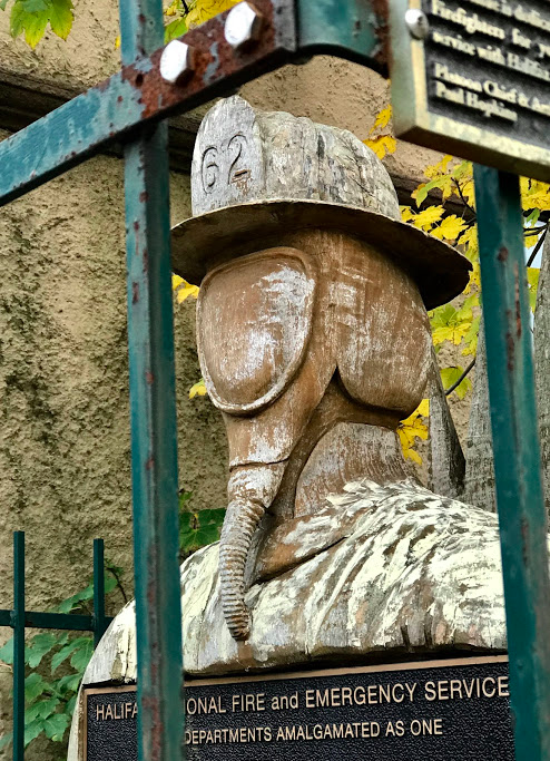 Found this well weathered, faceless, wooden fire fighter monument next to downtown fire station.