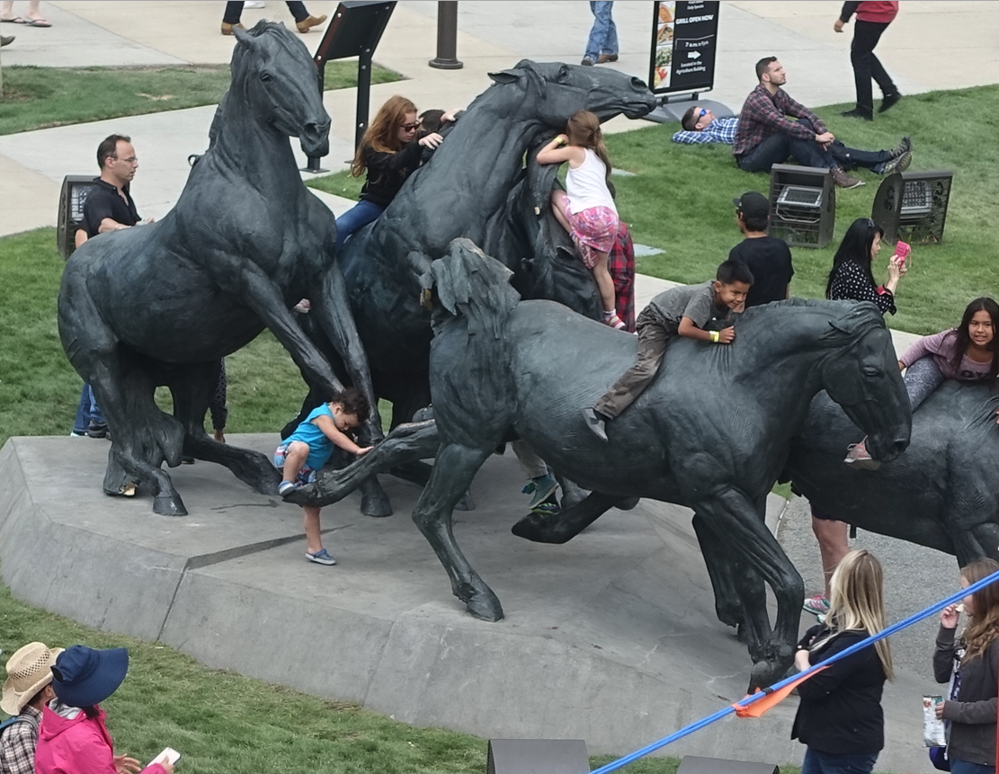 One of the most popular things to do at the Calgary Stampede is to climb all over the “By The Banks Of The Bow” bronze sculpture.