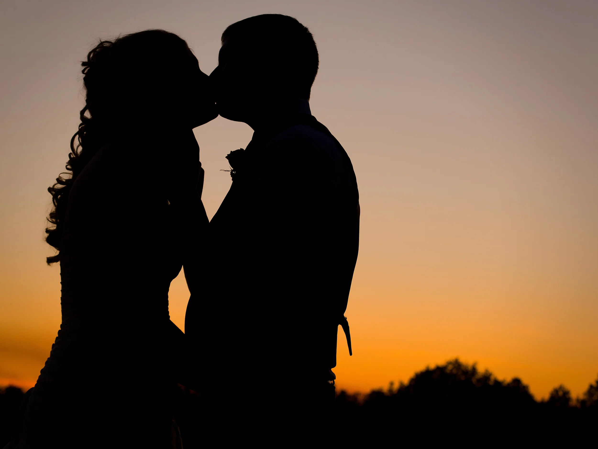 Sunset silhouette of bride and groom