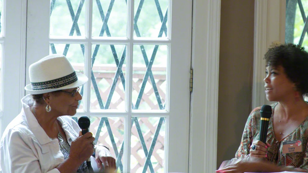 Donna Jackson, left, partner of artist Mildred Thompson, discusses the work with Re-Imagining curator, Tracy Murrell.