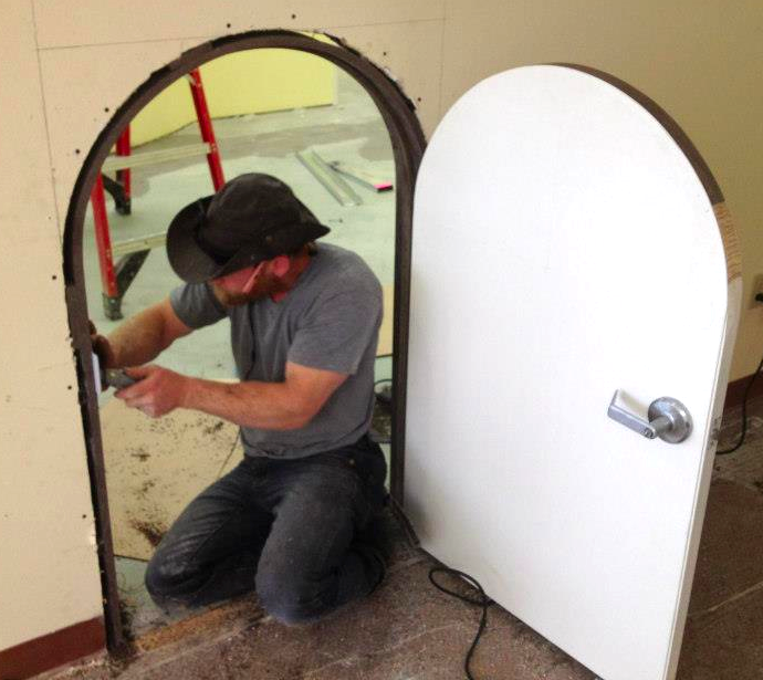 Carpenter installing custom build children's' door.