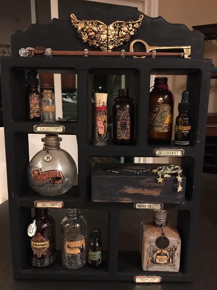 I added some embellishments on the bottles, found some other fun stuff to use with the cabinet including a brass key, one of the wands I'm working on and an old moon and stars pin that has a great patina. Time to put it all together... looking pretty good, but it needs a back, I'm thinking!