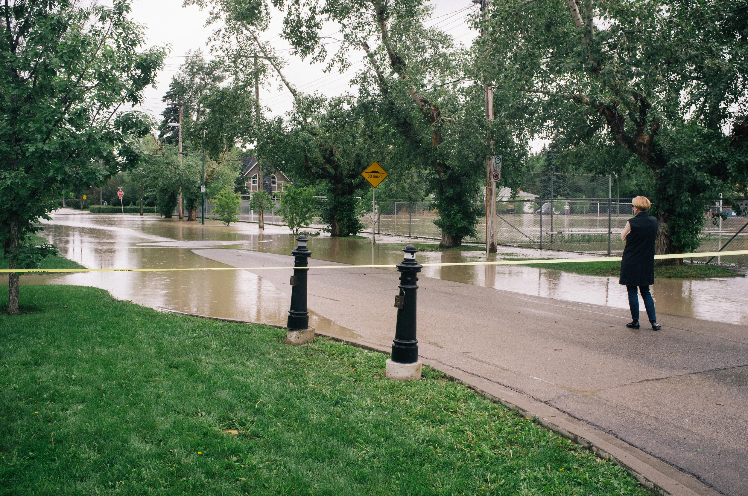 Locals surveying their homes. Shortly hereafter I ran into a coworker—her basement is flooded chest deep and she fears for her home. 38th Avenue SW and 7A Street.