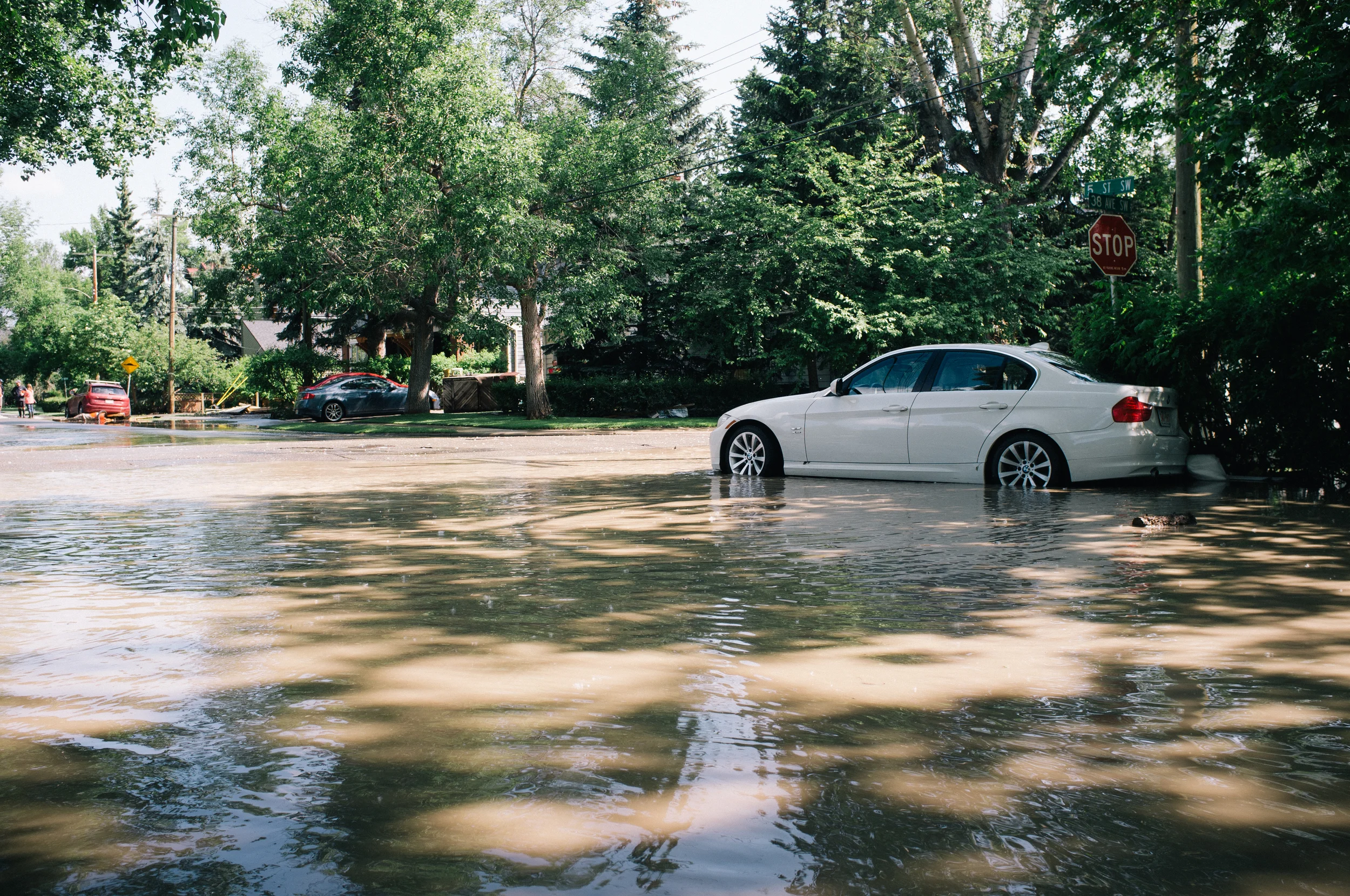 A flood-damaged BMW at the intersection of 38th Ave and 5th St. Elbow Park. A homeowner around the corner tells me last night the water was to the top of the wheel arches.