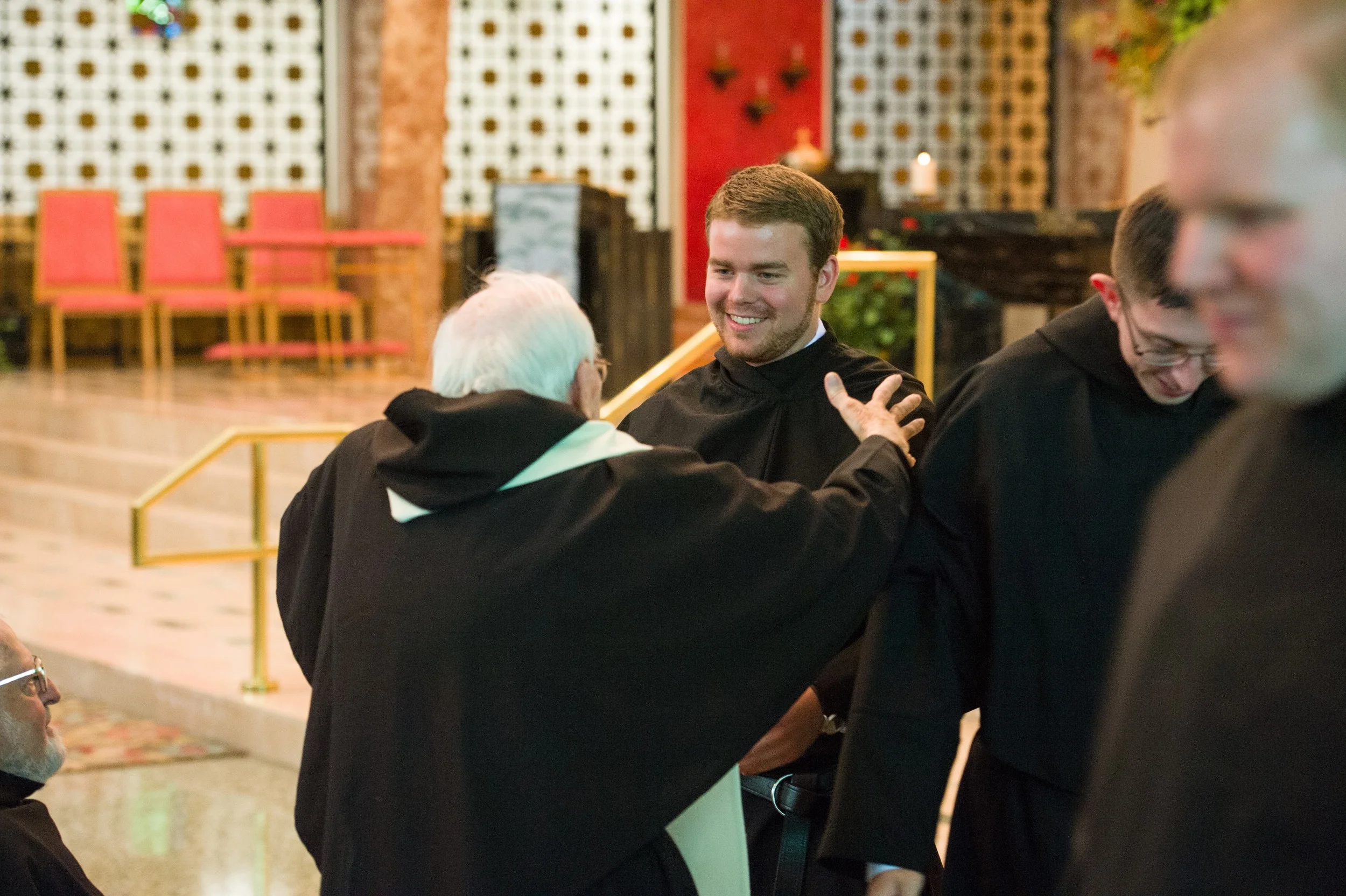 Brother Jeff Raths, O.S.A., embraces Fr. John Flynn, O.S.A., in his newly vested black habit