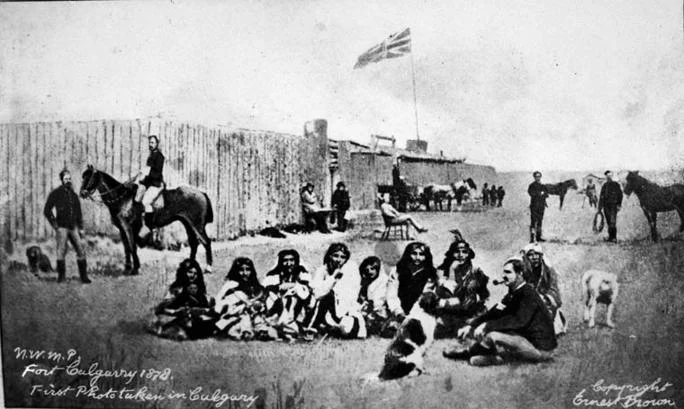 Fort Calgary, 1878, three years after Cecil Denny arrived at the confluence of the Bow and Elbow rivers. You can spot Denny sitting in the chair, mid-frame. This is said to be the first photograph of Calgary. (Photo: Ernest Brown)