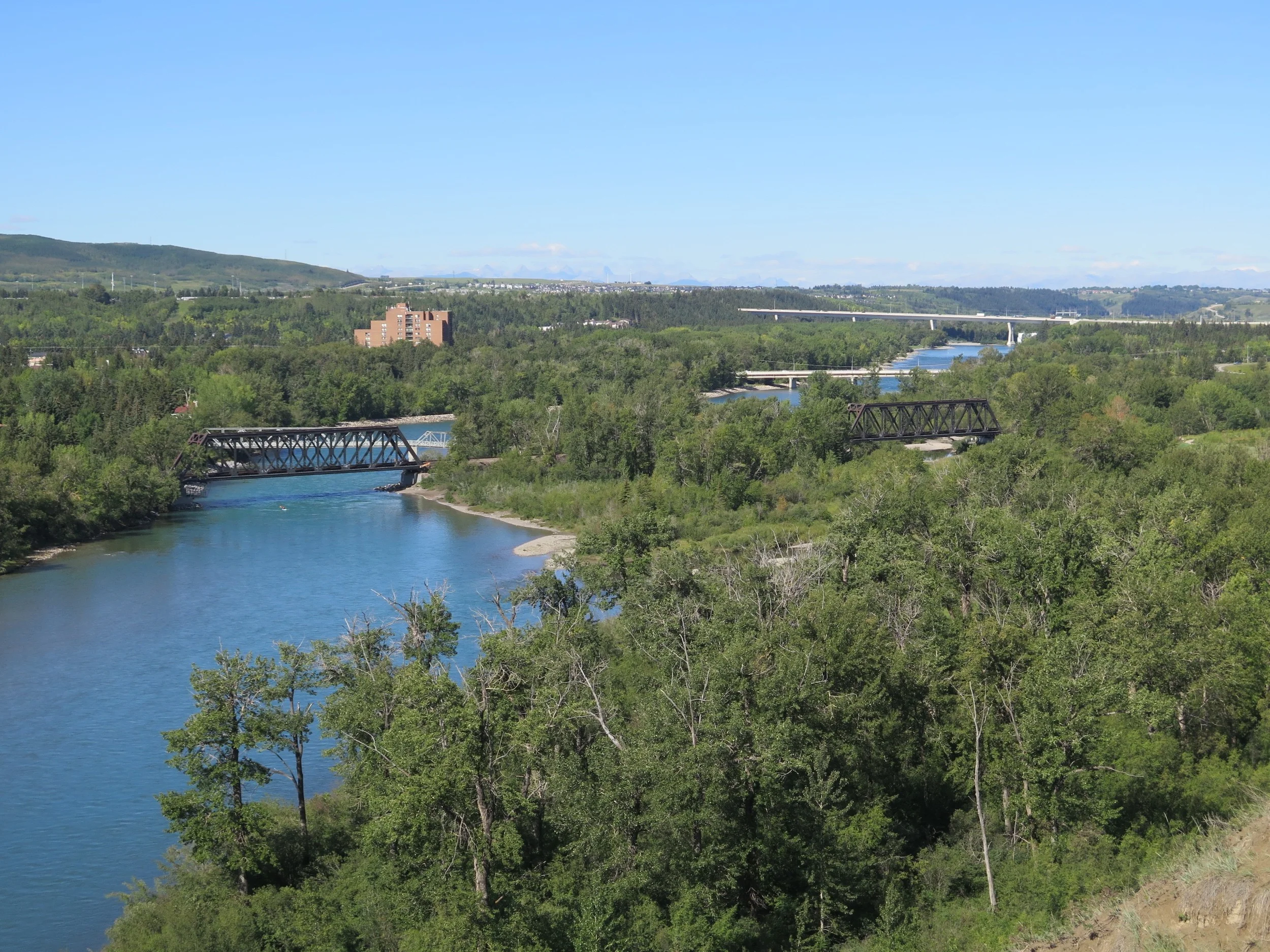The landmark twin railway bridges in Bowness, looking west from Bowmont Park, with Stoney Trail in the distance (Photo: Blair Carbert)