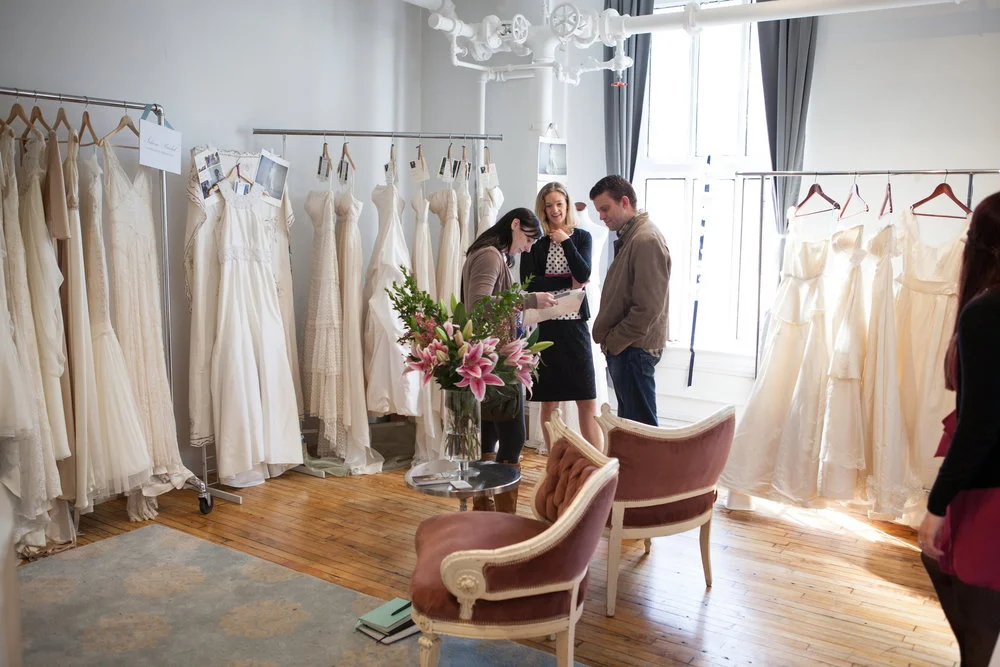 A designer talking to a couple about her collection. 