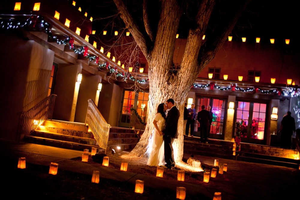 bride and groom kissing under lights, bride wearing vintage-inspired Audrey wedding gown by Winifred Bean