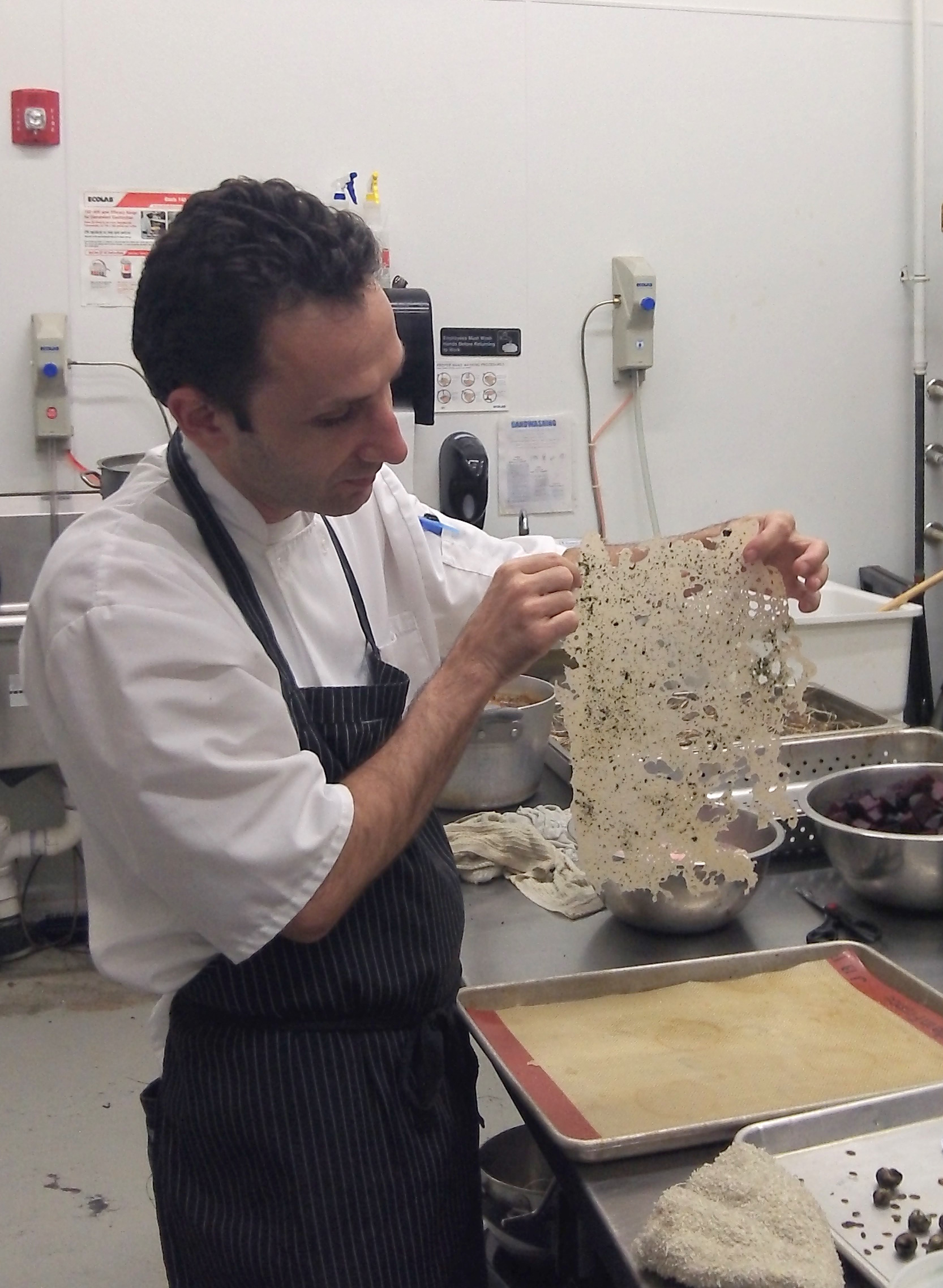 Chef Riz holds up a nori tuille for the cake