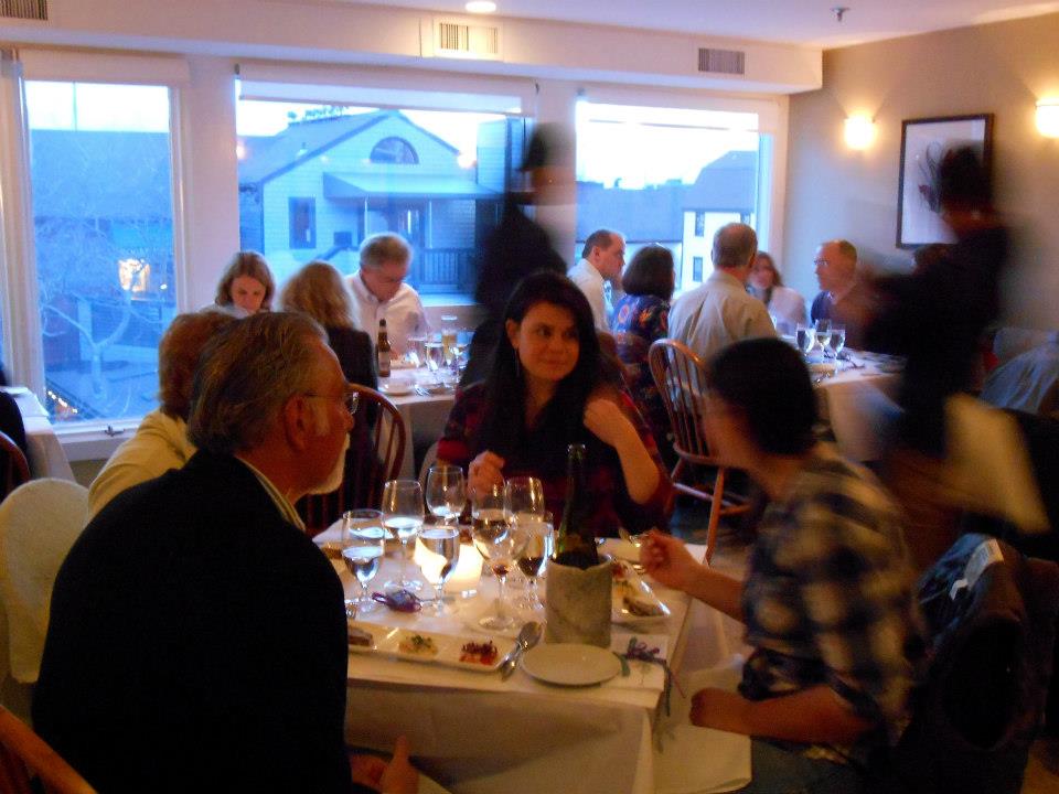 Guests enjoy the shellfish trio, with sunset occurring outside.