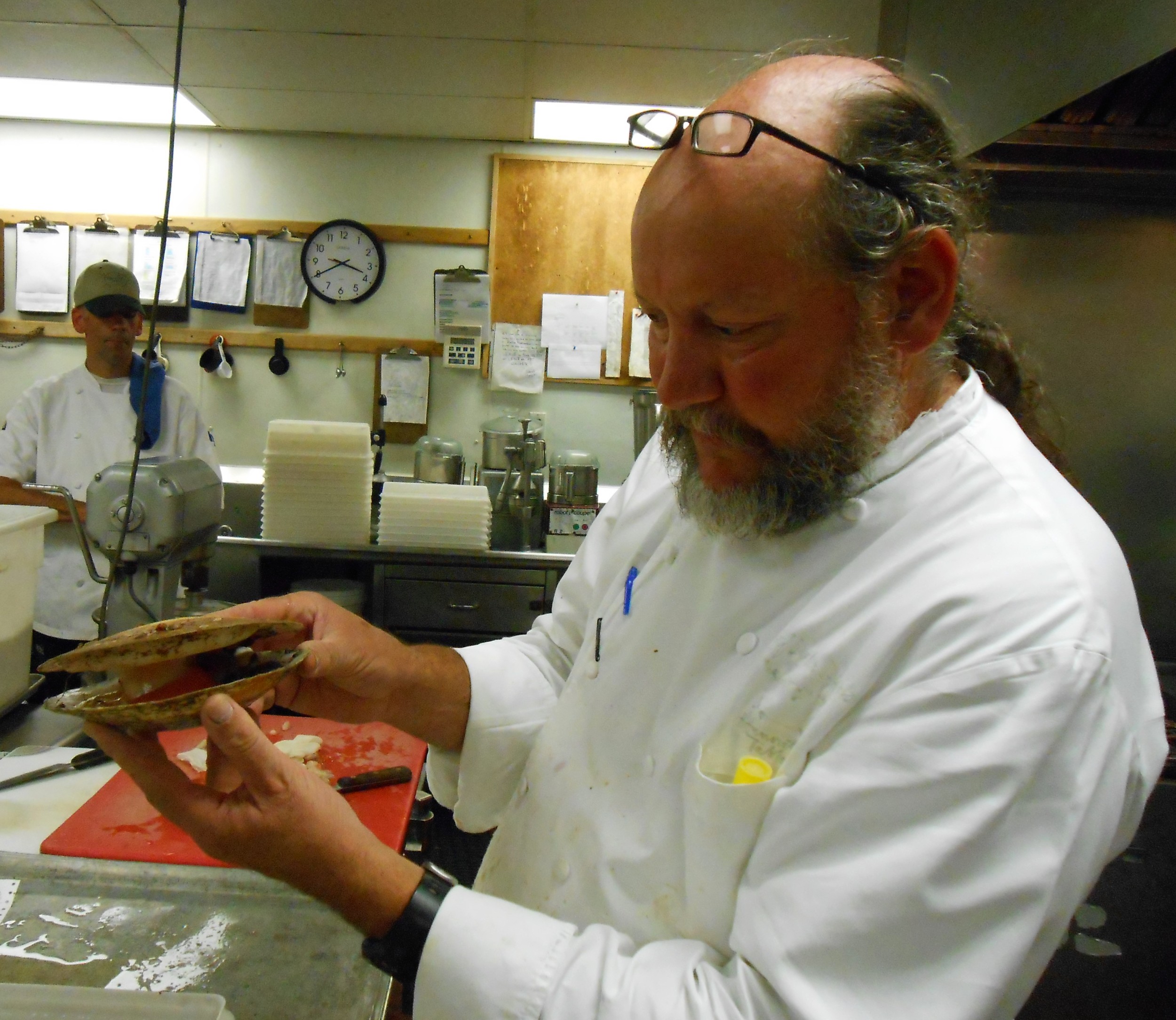 Chef Peter Davis examines a whole scallop.