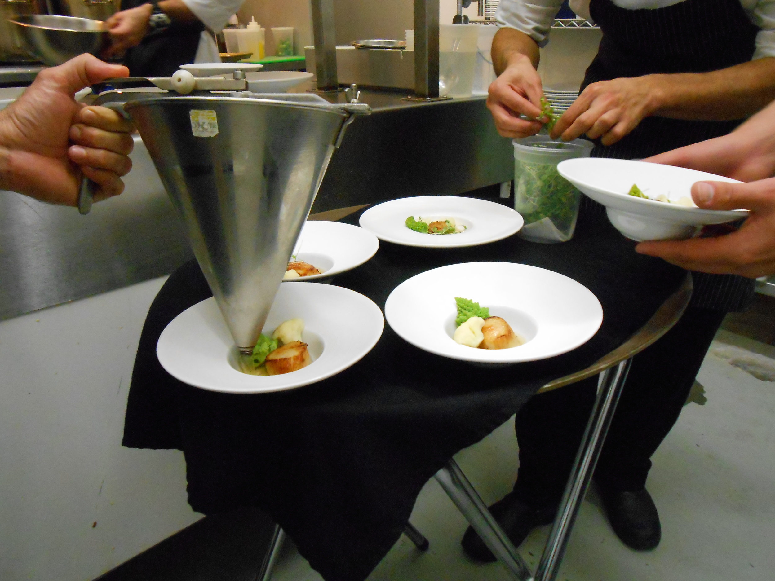 Chefs apply the final touches to the scallop dish