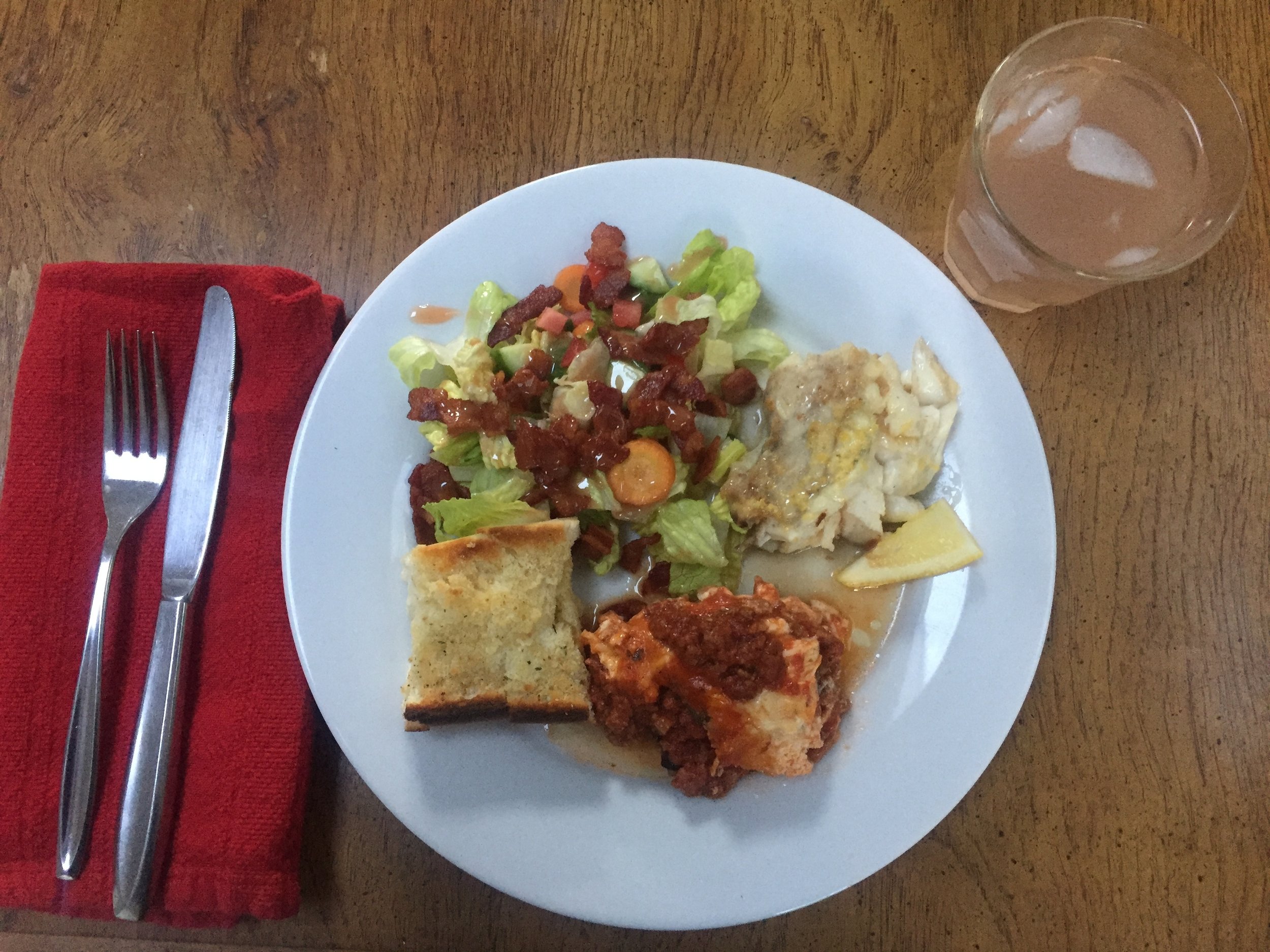 Broiled monkfish plated with zucchini lasagna, confetti salad and garlic bread