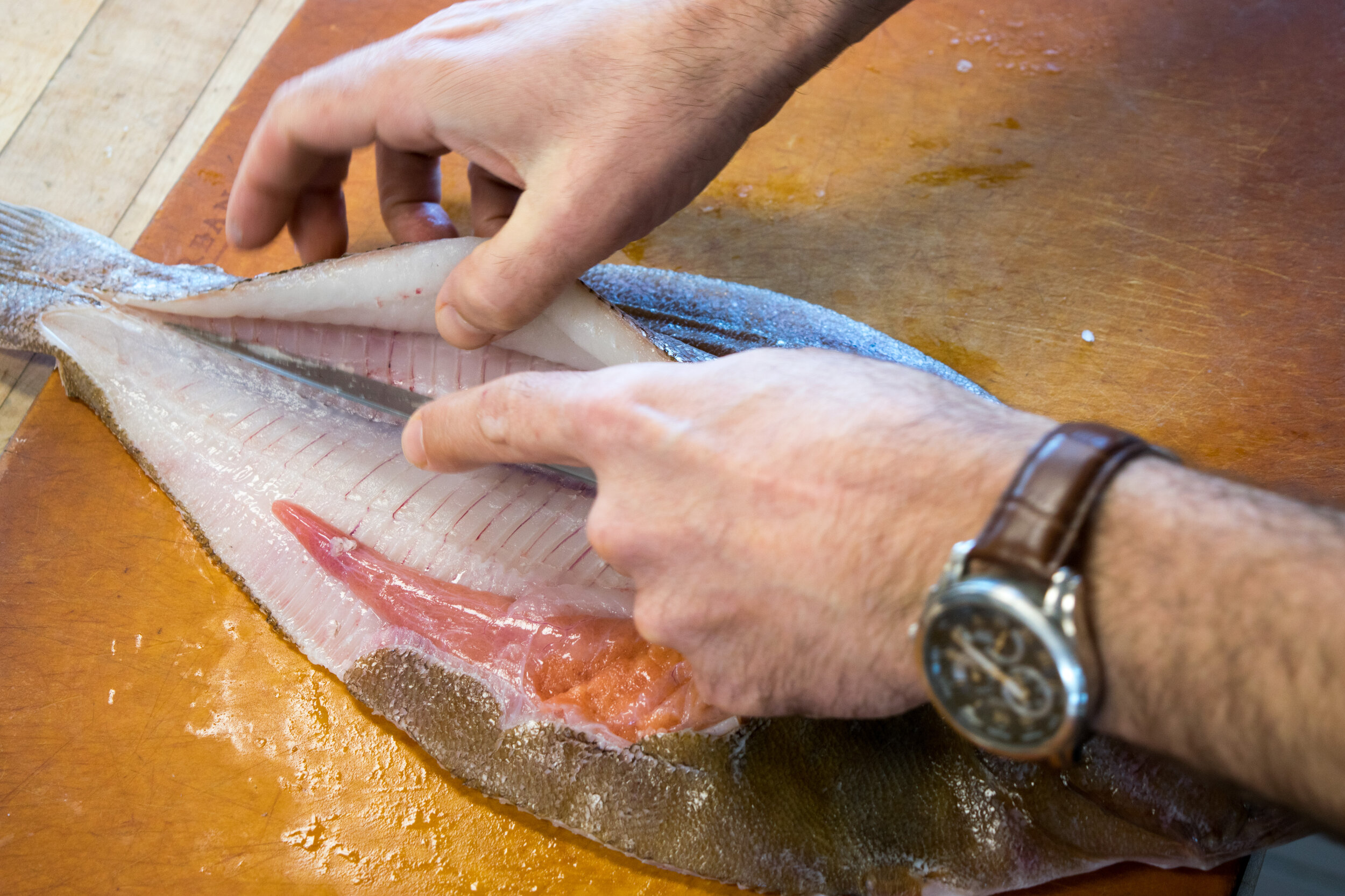 Step 6. Turn the fish around  and slide the knife under the flesh on the other side.