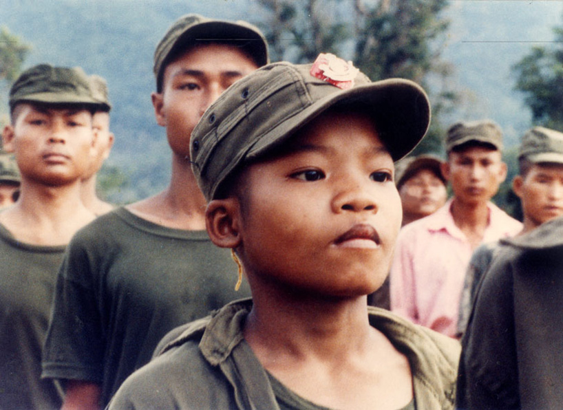 Newly enlisted Karen boy stands at attention in the light of early morning