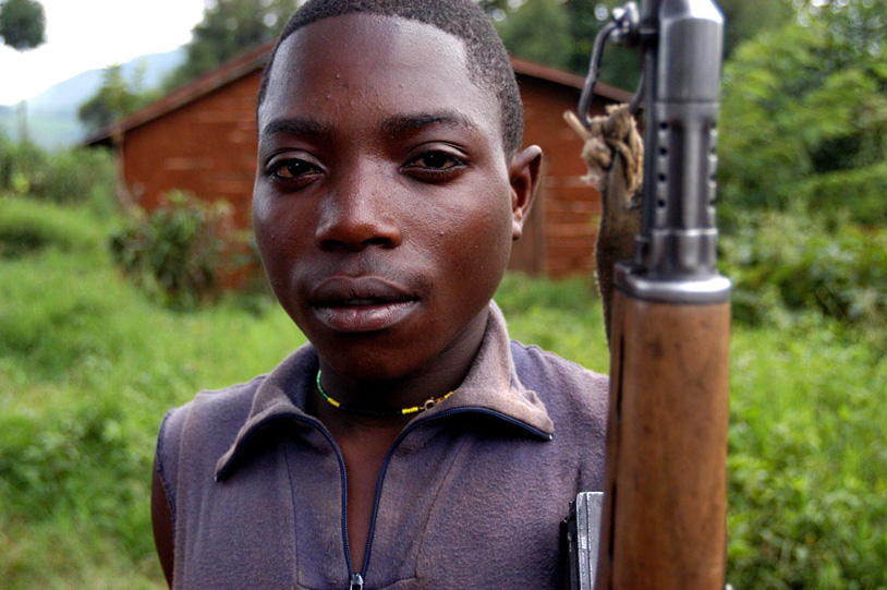 Ombeni Balihiamwabo, 17, stands with his rifle Thursday Dec. 9, 2004, outside a military post in Nyangonbe, in the Democratic Republic of Congo. The integration of the former militias in the new Congolese army is a priority task for the transitional government. Photo: Riccardo Gangale.