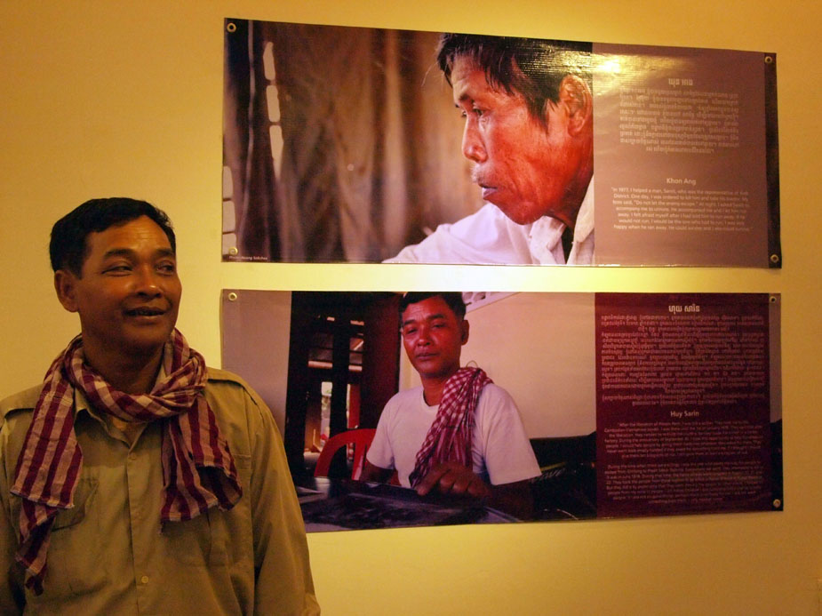  Cambodia rescuer Huy Sarin stands next to his story and photograph at The Rescuers exhibit in Cambodia, November 2011. Photo: Willhemina Wahlin. 