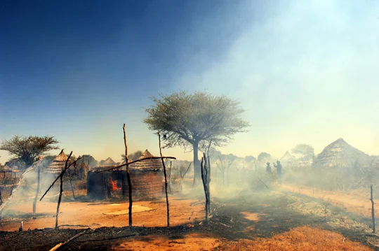 2005 - The village of Tama, Sudan, burning. Photo: Lynsey Addario.