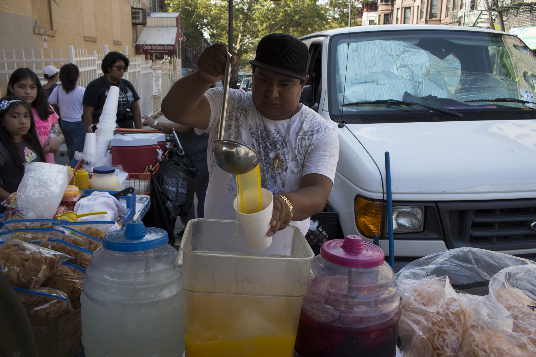  Sergio pouring jugo de mango for eager customers on the 22nd of August, 2017. Sunset Park, Brooklyn 