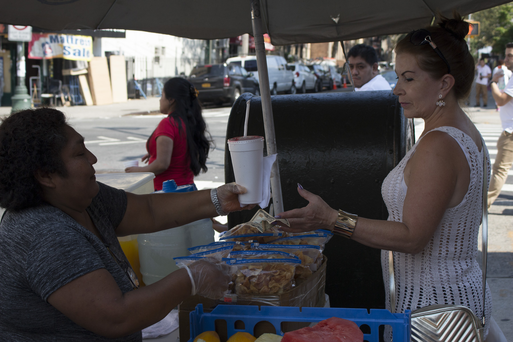  An exchange between Teodosia and one of her customers in Sunset Park, Brooklyn. August 22nd, 2017. 