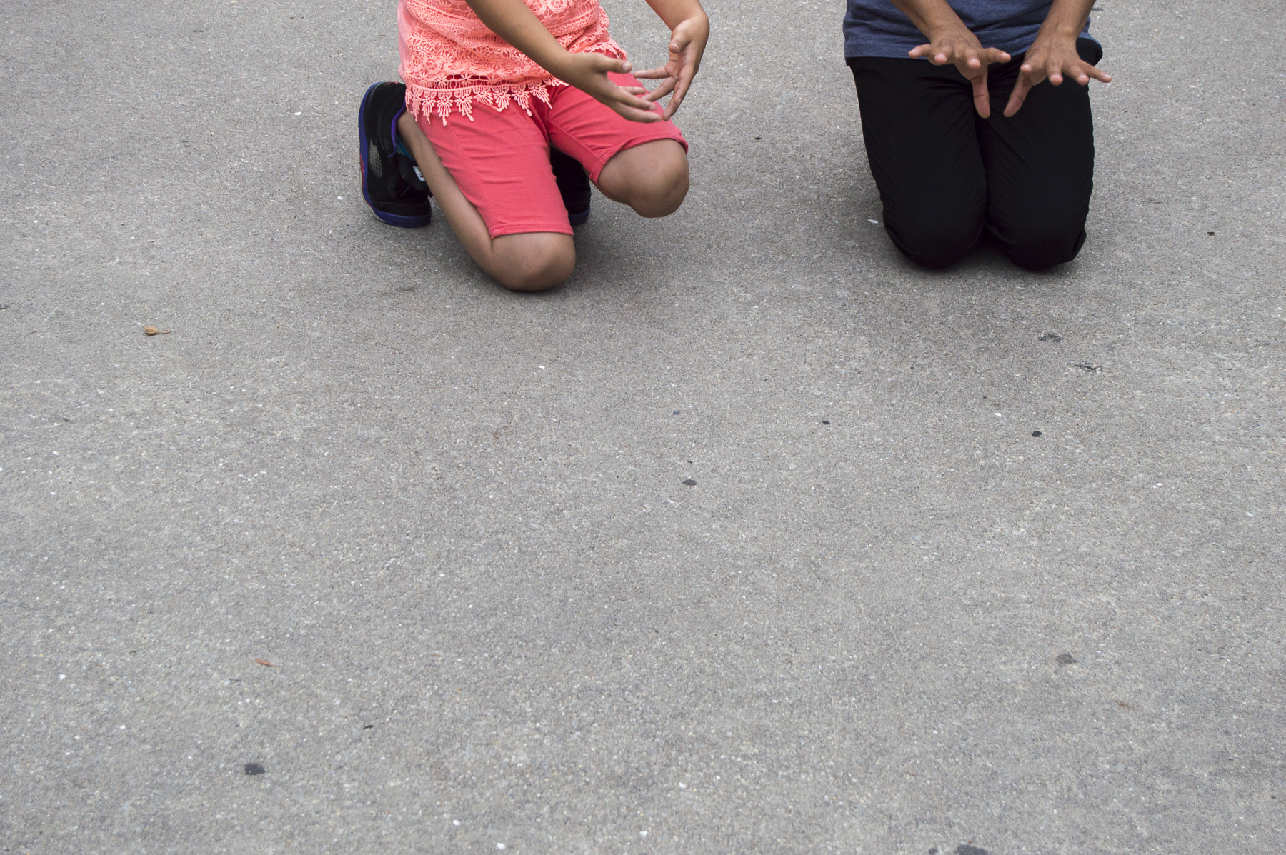 Benito Bravo shows the young girl her steps. Later, the quinceñera and her younger sister will dance with dolls to symbolize the last toy the quinceñera has before becoming an adult. Gabrielle Narcisse and Deleelah Saleh for Picture Justice. August 17th, 2017, Brooklyn, Hena Perrera Park, 47th and 4th ave.
