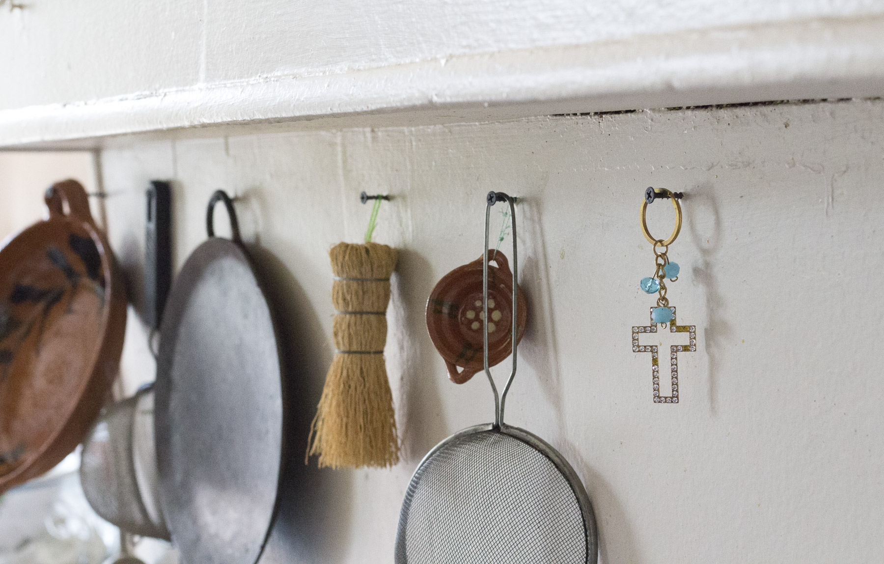  A detail of a cross hanging next to other items in Benito Bravo’s kitchen. Gabrielle Narcisse and Deleelah Saleh for Picture Justice.&nbsp;August 22, 2017. 